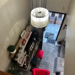 Quarto interno com iluminação clara e móveis escuros.