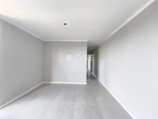 Hall de entrada com piso claro e paredes brancas.