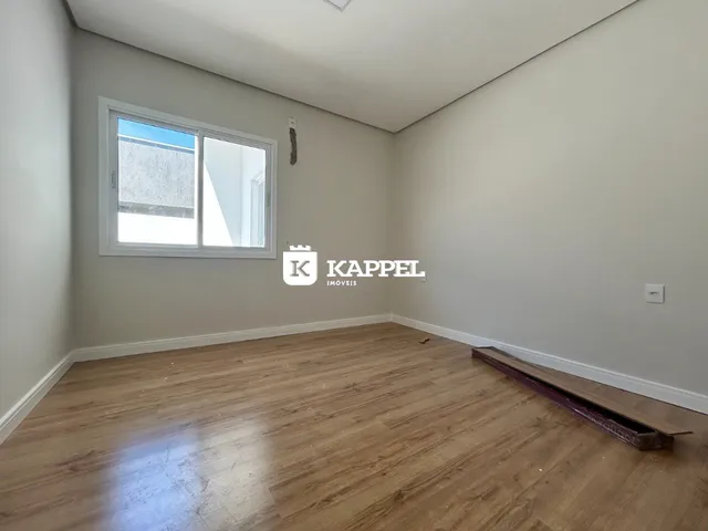 Foto de um cômodo interno com piso de madeira e paredes claras.