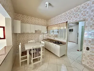 Foto de uma sala de jantar com armários brancos e piso de cerâmica.