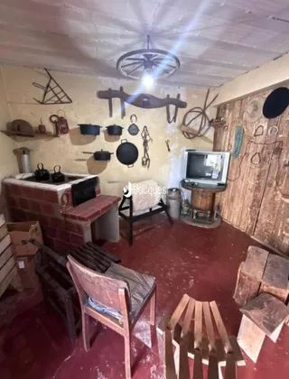 Interior rústico com lareira de tijolos e piso de madeira em uma residência.