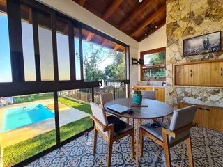 Sala de jantar com vista para a piscina e jardim externo