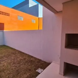 Vista de uma parede branca com piso de carpete marrom em um ambiente interno.
