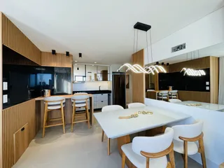 Ambiente de cozinha e jantar moderno com painéis de madeira em Lajeado.