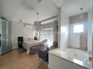 Quarto com cama e piso de madeira em um imóvel no Brasil.