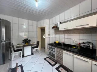 Interior de uma cozinha e sala de jantar com revestimento de cerâmica branca.