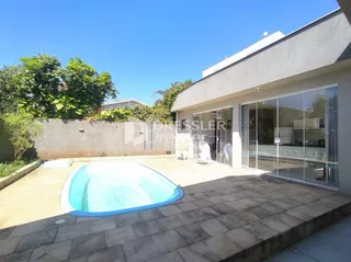 Foto da fachada de uma residência com piscina no exterior.