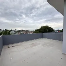 Varanda externa com piso de concreto exposto.