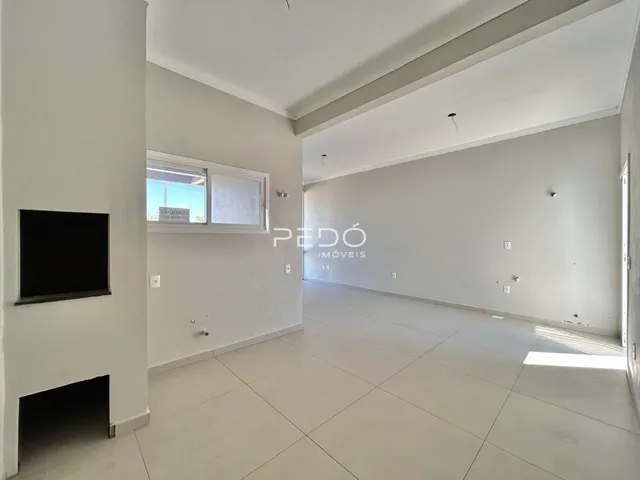 Ambiente interno de uma sala ampla com piso de cerâmica clara.