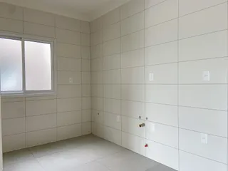 Ambiente interno com paredes claras e piso de cerâmica em um imóvel.