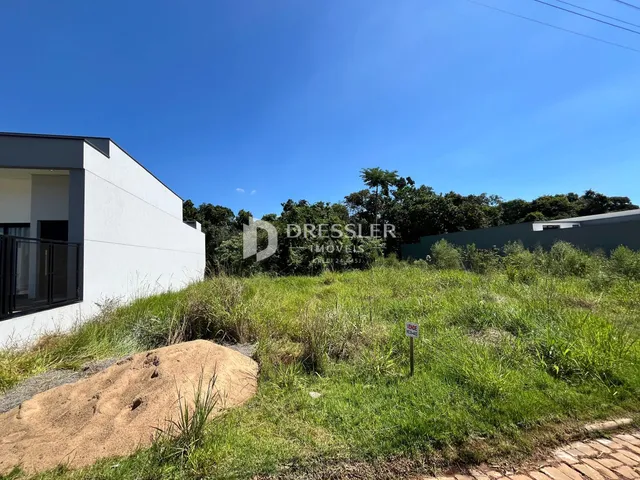 Fachada de uma residência em Lajeado, Brasil, com vegetação densa no primeiro plano.