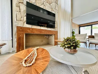 Sala de estar com lareira de pedra e decoração moderna.