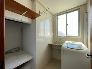 Foto de um banheiro com paredes de azulejo branco e uma janela.