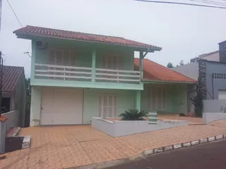 Fachada de uma casa em Lajeado, Brasil, com garagem e varanda no segundo andar.