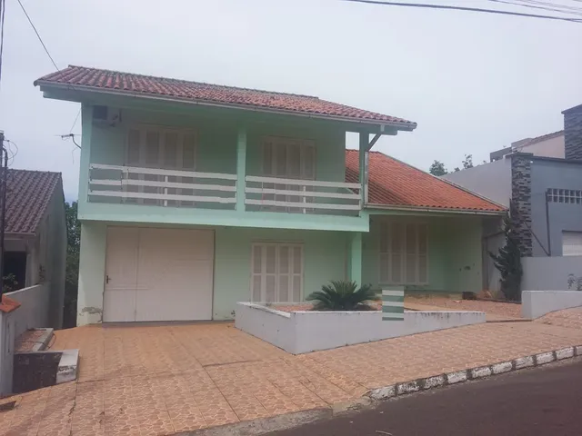 Fachada de uma casa em Lajeado, Brasil, com garagem e varanda no segundo andar.