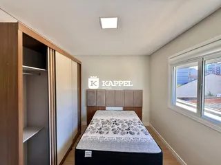 Quarto com cama e armário de madeira em um apartamento.