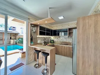 Cozinha moderna com ilha e acesso à área externa da residência.