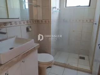 Foto de um banheiro com revestimento de azulejos brancos e box de vidro.