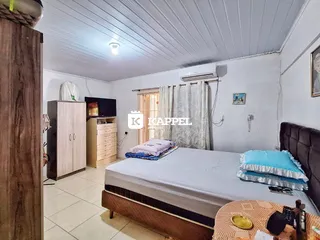 Quarto com cama e armário de madeira em um apartamento.
