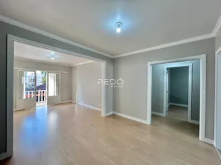 Interior de uma área de passagem com piso de madeira clara.