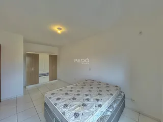 Quarto com cama e armários em um imóvel de Lajeado.
