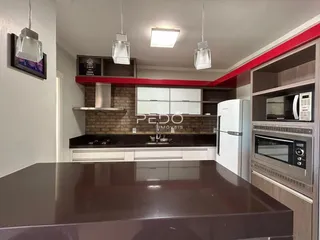 Cozinha moderna com armários brancos e eletrodomésticos em aço inoxidável.
