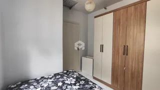 Quarto com armário de madeira e cabeceira.