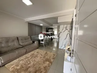 Sala de estar com sofá e área de jantar em um apartamento.