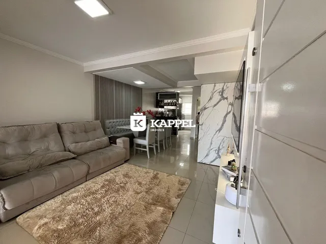 Sala de estar com sofá e área de jantar em um apartamento.