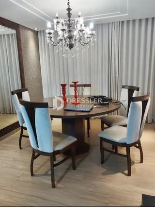 Sala de jantar com mesa e cadeiras decorativas em um ambiente claro.