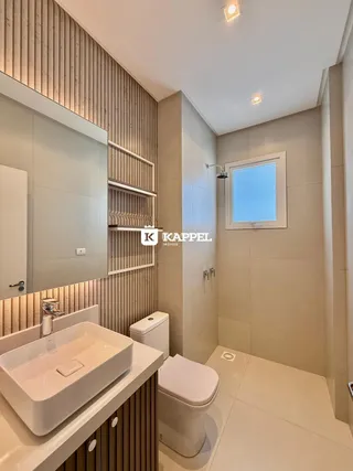 Banheiro moderno com bancada branca e piso claro.