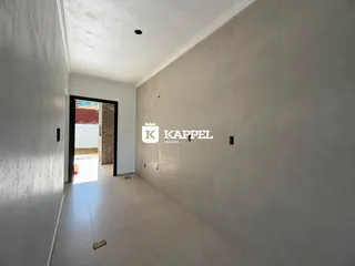 Foto de um corredor interno com paredes brancas e piso claro.
