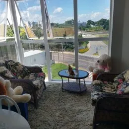 Sala de estar com grandes janelas que oferecem uma vista externa.