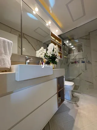 Foto de um banheiro moderno com bancada de mármore e box de vidro.