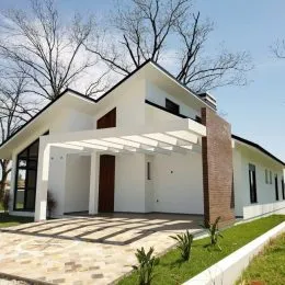 Fachada externa de uma casa branca com telhado escuro em Lajeado, Brasil.