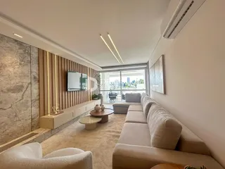Sala de estar com sofá e painel de madeira em um imóvel no Brasil.