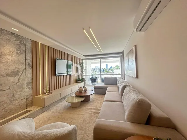 Sala de estar com sofá e painel de madeira em um imóvel no Brasil.