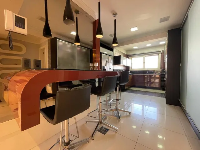 Foto de uma cozinha moderna com ilha central e luminárias pendentes.
