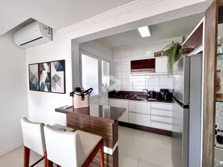 A cozinha e a sala de jantar estão integradas em um ambiente claro.