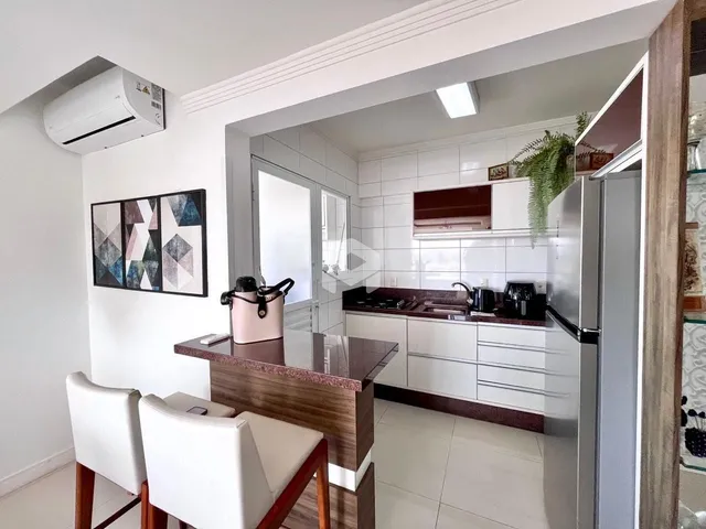 A cozinha e a sala de jantar estão integradas em um ambiente claro.