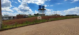 Vista da propriedade com terreno e estrutura no fundo.