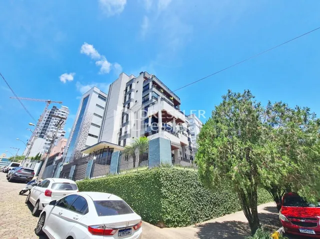 Fachada de um edifício residencial em Lajeado, Brasil, com cerca e vegetação ao redor.