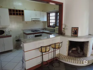 Sala de estar com lareira e armários brancos.