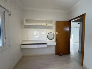 Ambiente interno com paredes brancas e piso de madeira clara.
