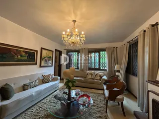 Sala de estar com sofá branco e decoração de madeira.