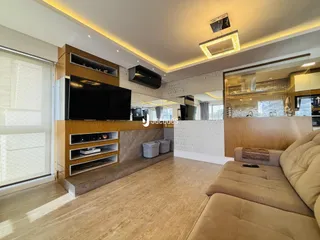 Sala de estar moderna com painel de madeira e sofá claro.