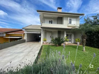 Fachada de uma residência em Lajeado, Brasil, com jardim e entrada de garagem.