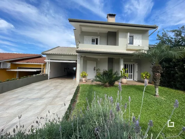 Fachada de uma residência em Lajeado, Brasil, com jardim e entrada de garagem.