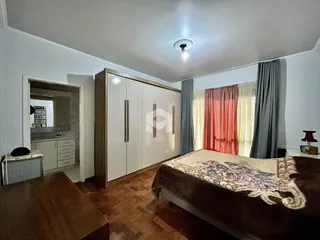 Quarto com armário e cama em ambiente interno.