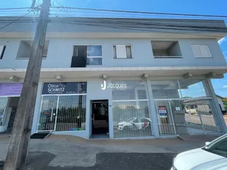 Fachada de um imóvel residencial em Lajeado, Brasil, com vitrines comerciais na frente.